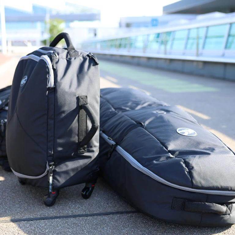 Schwarze Reisetasche und Skitasche auf dem Weg, ideal für den Transport von Ski und Ausrüstung.