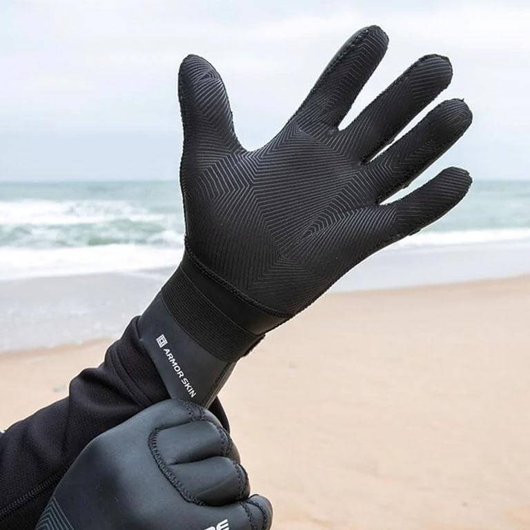 Schwarze Neoprenhandschuhe für Wassersport am Strand, ideal für kaltes Wetter und Schutz vor Wasser.