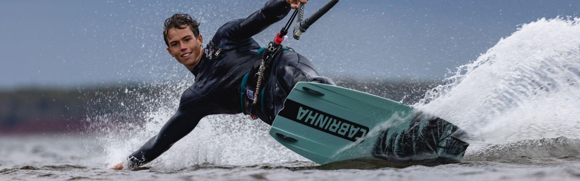 Kitesurfer, der mit einem Cabrinha Board auf dem Wasser surft, ideales Bild für Online Surfshop.