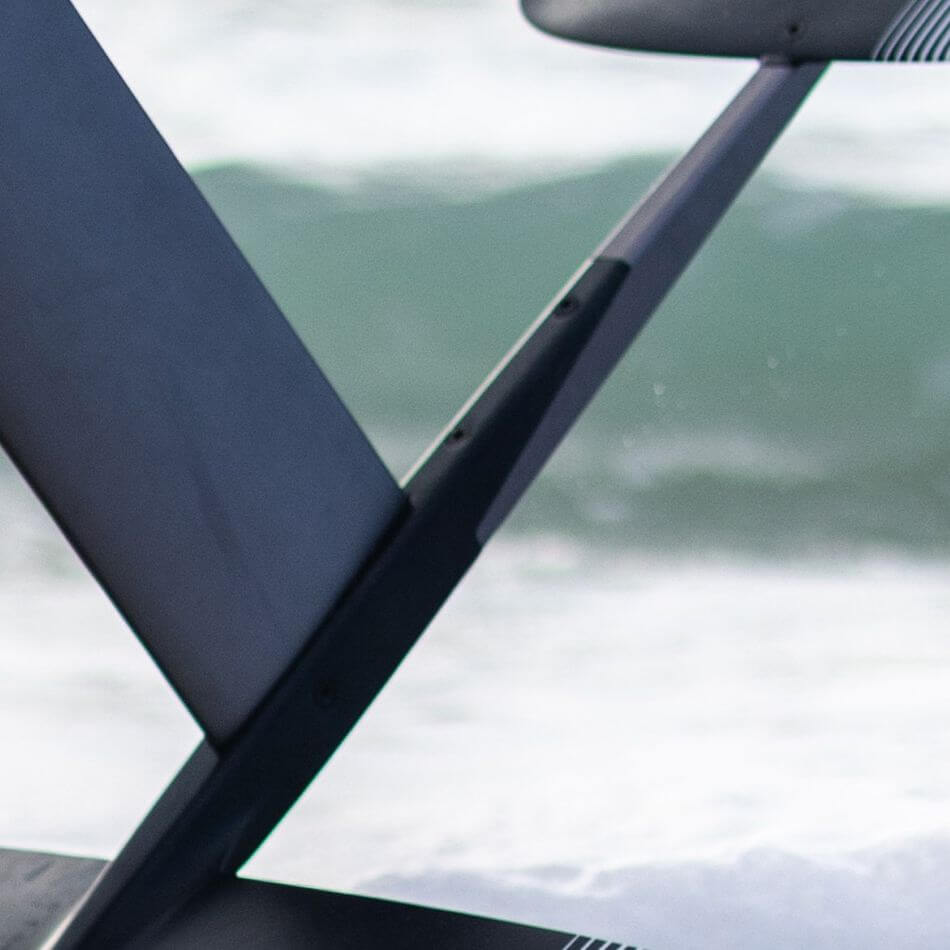Detailaufnahme eines Foils vor einer dynamischen Wellenkulisse, ideal für Wassersport-Enthusiasten.